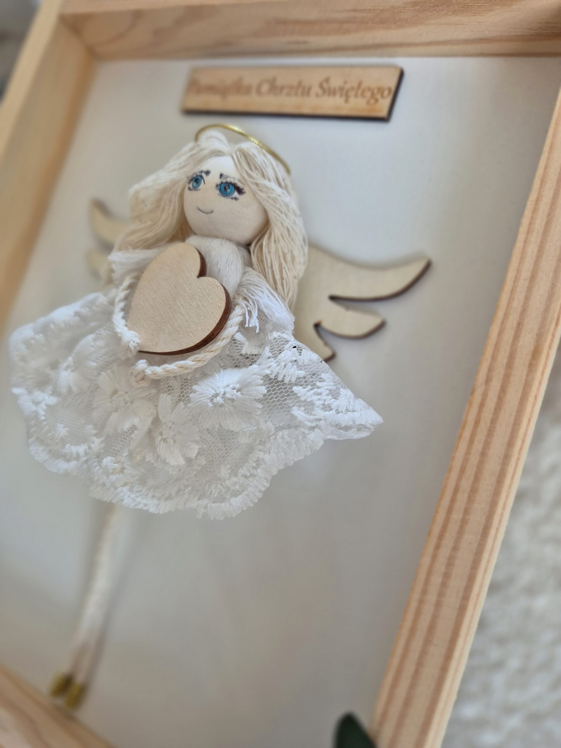 Anioł stróż w ramce - spojrzenie na koronkową sukienkę.