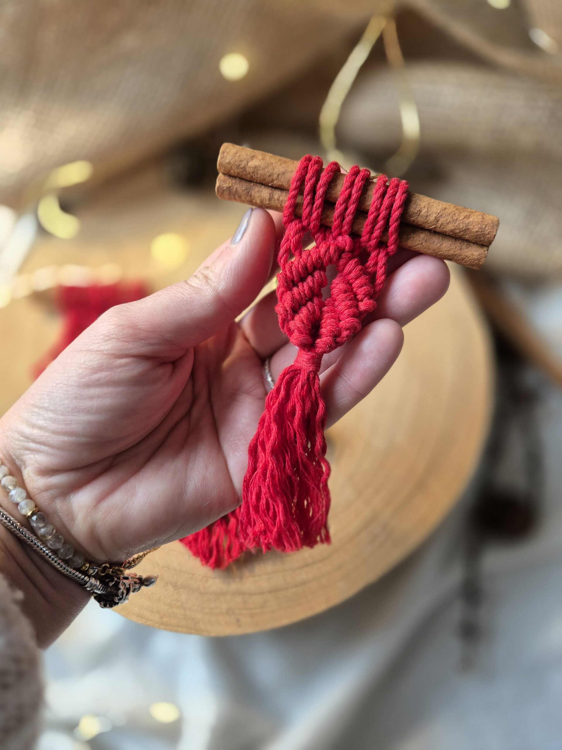 Makramowa ozdoba na cynamonie w pięknej czerwieni